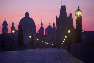 Charles Bridge in Prague at sunrise with soft golden light