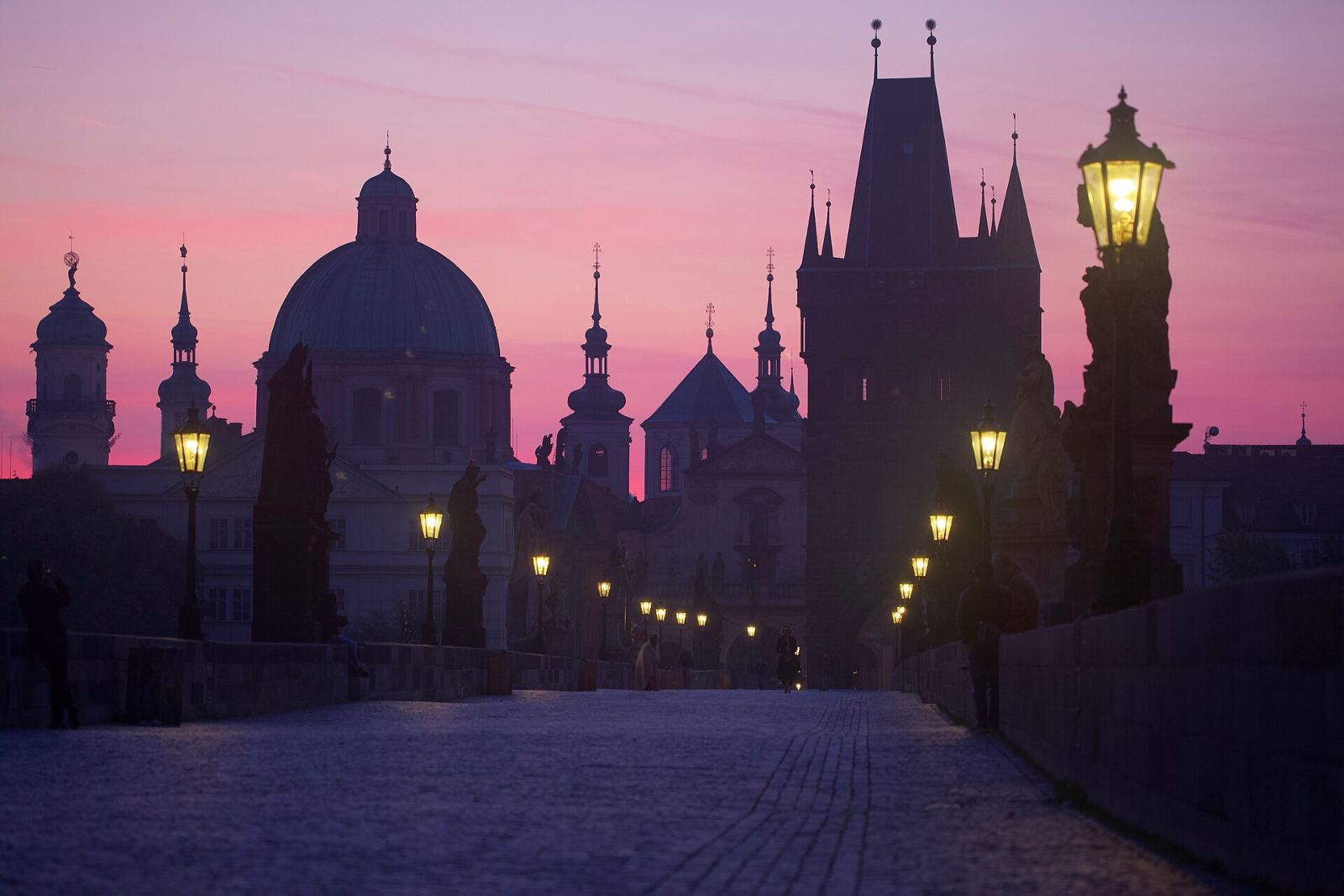 Charles Bridge in Prague at sunrise with soft golden light