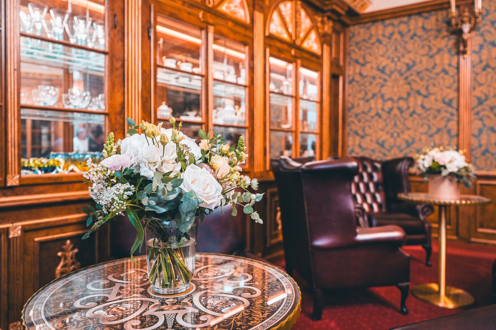 Wood-panelled lounge with fresh flowers at Hotel Haštal Prague