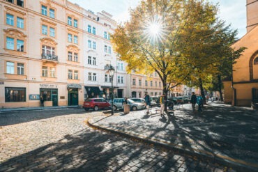 Autumn sunlight through a tree on a cobbled square near Hotel Haštal in Prague