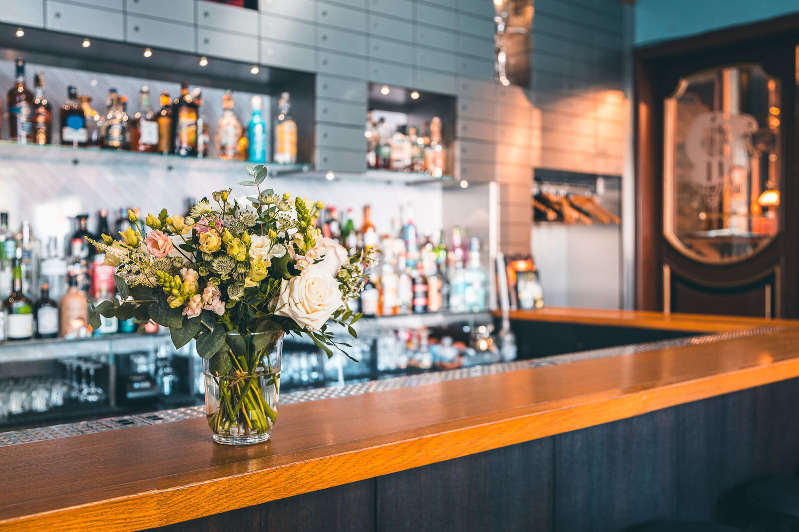 Wooden bar counter with fresh flowers at Hotel Haštal Prague