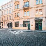 Green entrance door of Hotel Haštal, a family-run boutique hotel on a cobbled street in Prague Old Town