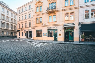 Green entrance door of Hotel Haštal, a family-run boutique hotel on a cobbled street in Prague Old Town