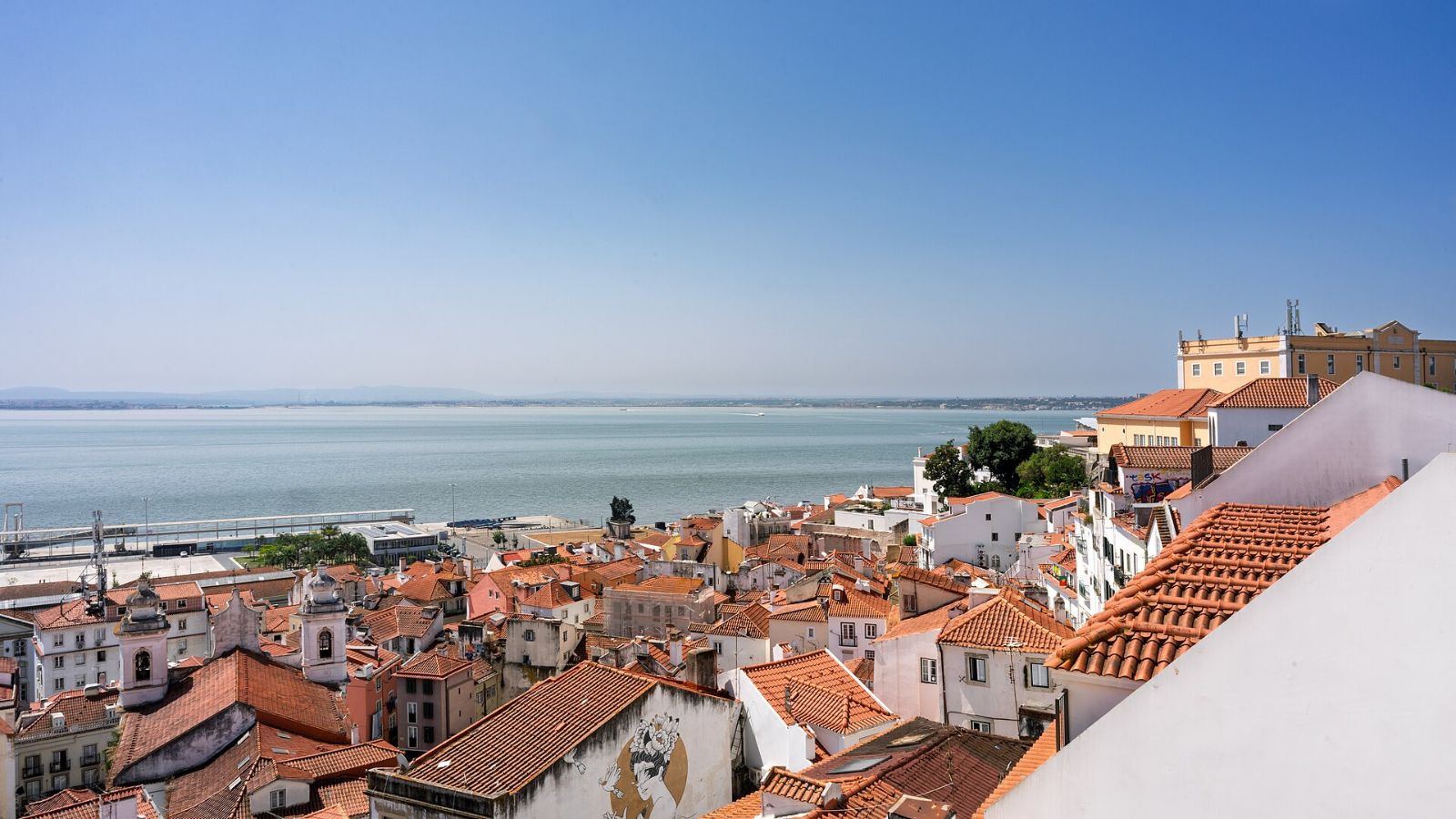 Rooftops of the Alfama district in Lisbon with the Tagus river beyond